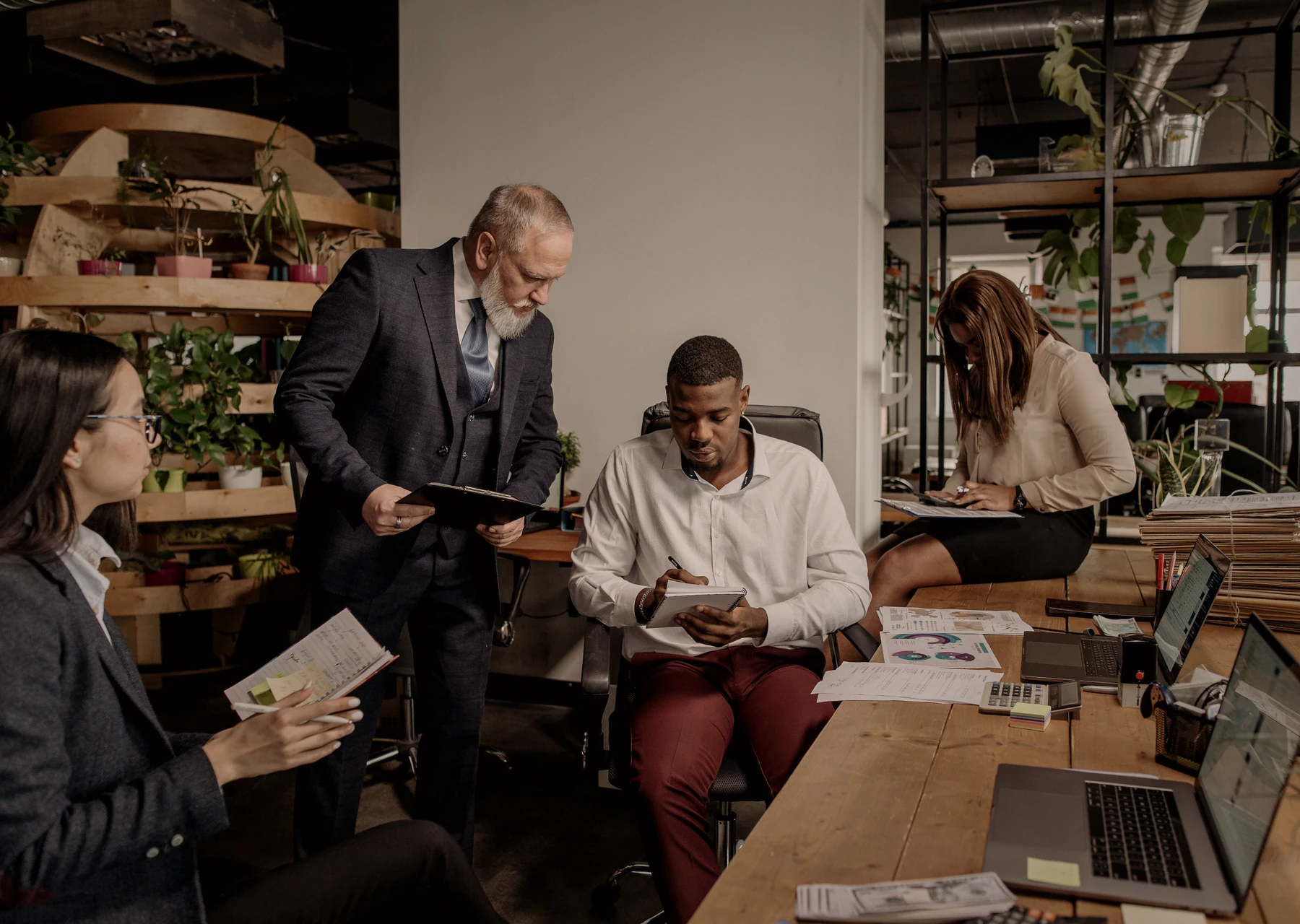 A real technology team discussing work at computer screens in a modern office