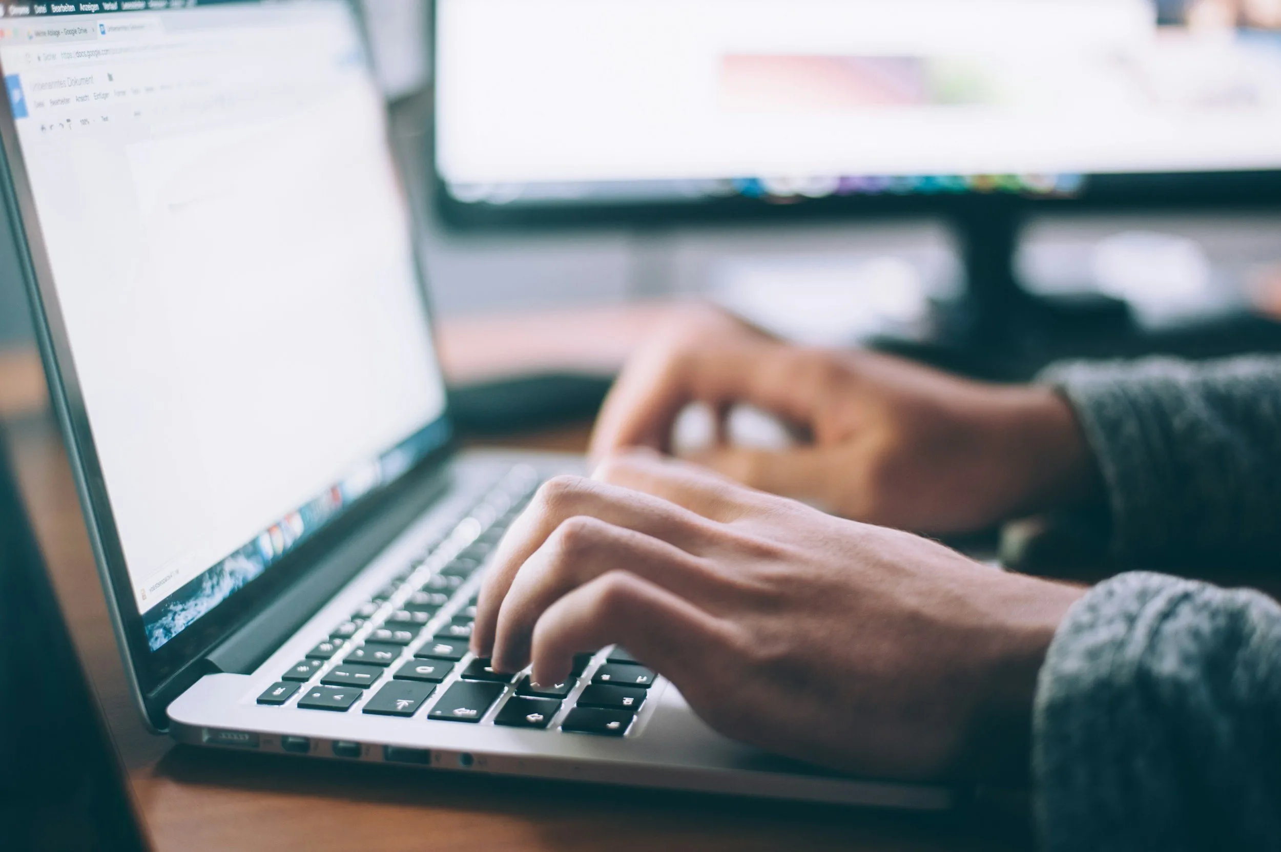 A person typing on a laptop doing IT work for a law firm.